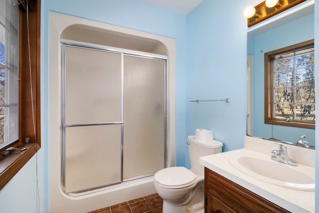 full bathroom featuring toilet, a stall shower, vanity, and tile patterned flooring