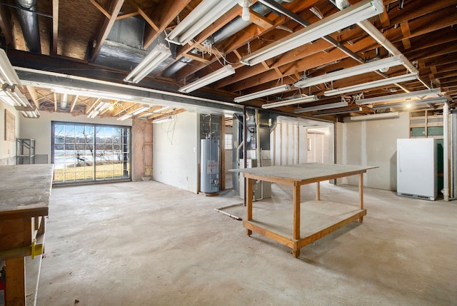 basement with heating unit, water heater, and freestanding refrigerator