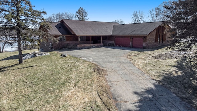 view of front of home featuring a front lawn, an attached garage, brick siding, and driveway