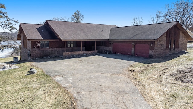 view of front of house with brick siding, a front yard, a garage, and roof with shingles