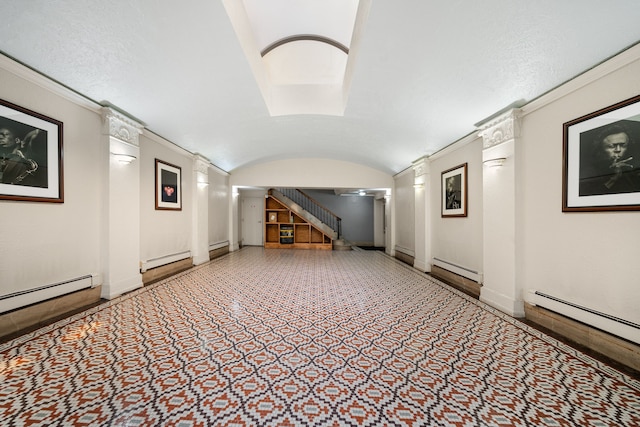 corridor with vaulted ceiling, stairway, baseboard heating, and baseboards