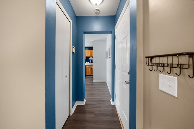 hall with dark wood-type flooring and baseboards