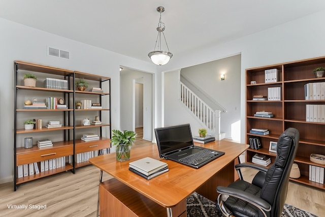 office with light wood-type flooring and visible vents