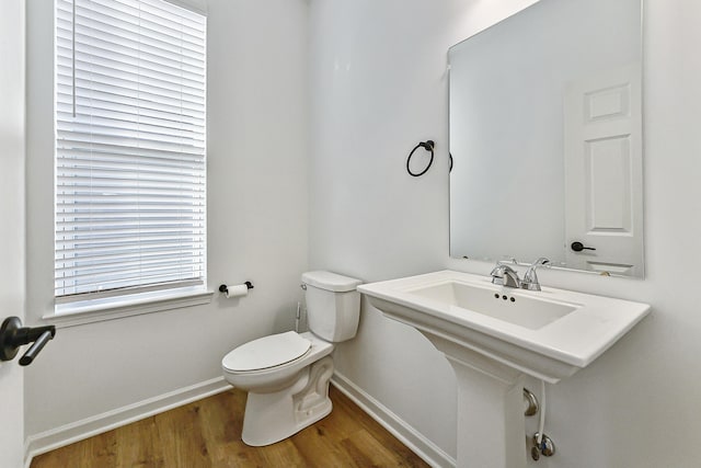 bathroom featuring toilet, baseboards, and wood finished floors