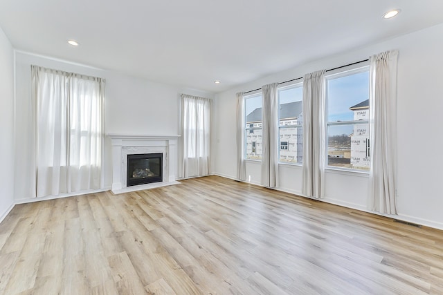 unfurnished living room with recessed lighting, visible vents, a fireplace, and wood finished floors