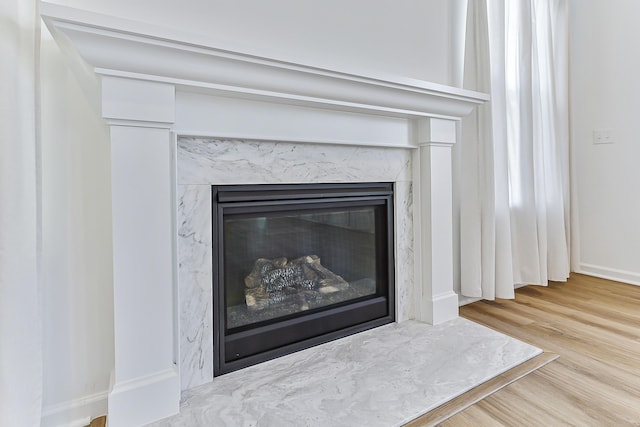 room details with a fireplace, wood finished floors, and baseboards