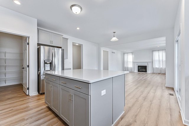 kitchen featuring light wood-style floors, gray cabinets, visible vents, and stainless steel refrigerator with ice dispenser