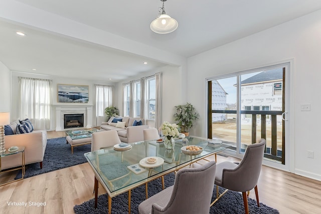 dining area featuring light wood-style floors, recessed lighting, a fireplace, and baseboards