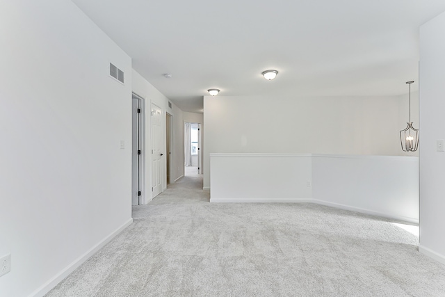 empty room with light colored carpet, visible vents, and baseboards