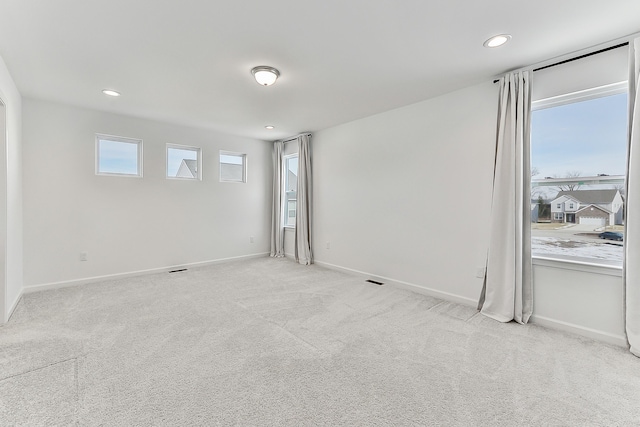 carpeted empty room with baseboards, a wealth of natural light, and recessed lighting