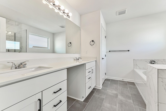 bathroom featuring a garden tub, double vanity, a sink, and visible vents