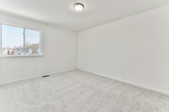 carpeted empty room with visible vents and baseboards