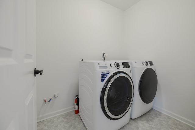 clothes washing area with laundry area, baseboards, light floors, and independent washer and dryer