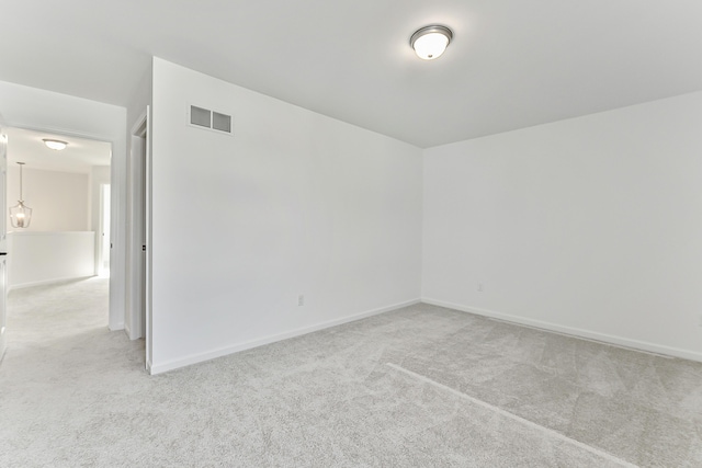 empty room featuring carpet floors, baseboards, and visible vents