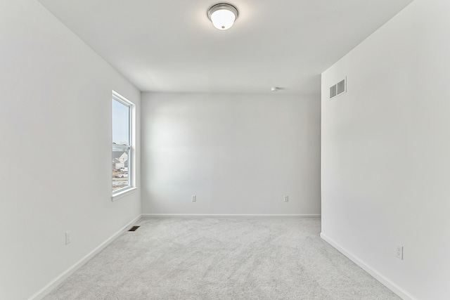 carpeted spare room featuring baseboards and visible vents