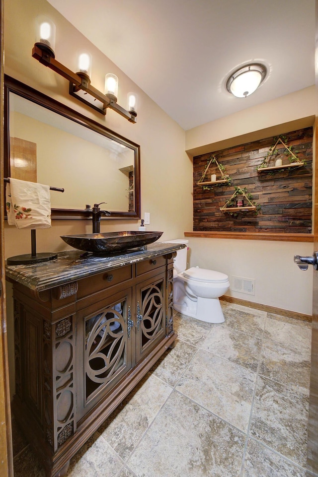 bathroom with toilet, baseboards, visible vents, and vanity