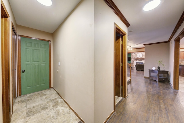 corridor featuring crown molding, baseboards, and wood finished floors