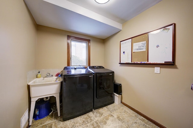 washroom with laundry area, visible vents, baseboards, and washing machine and clothes dryer