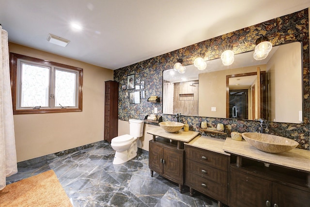 full bath with toilet, a sink, visible vents, and baseboards