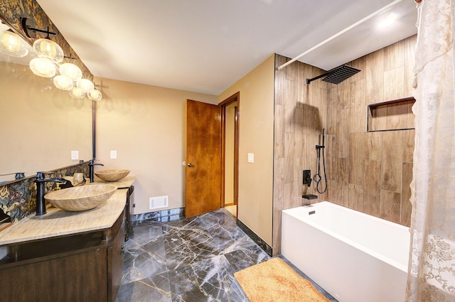 bathroom featuring washtub / shower combination, marble finish floor, visible vents, and a sink