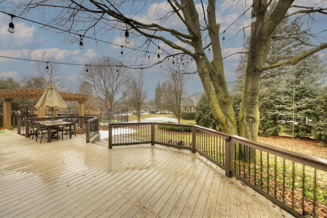 wooden deck with outdoor dining area and a pergola