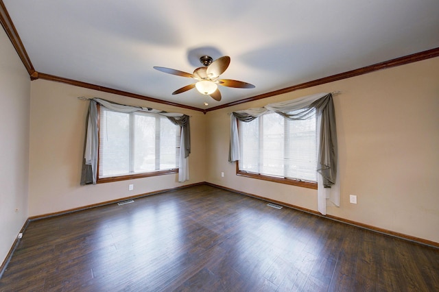 empty room featuring dark wood-style flooring, visible vents, crown molding, and baseboards