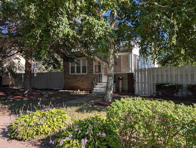 view of front facade with fence and brick siding