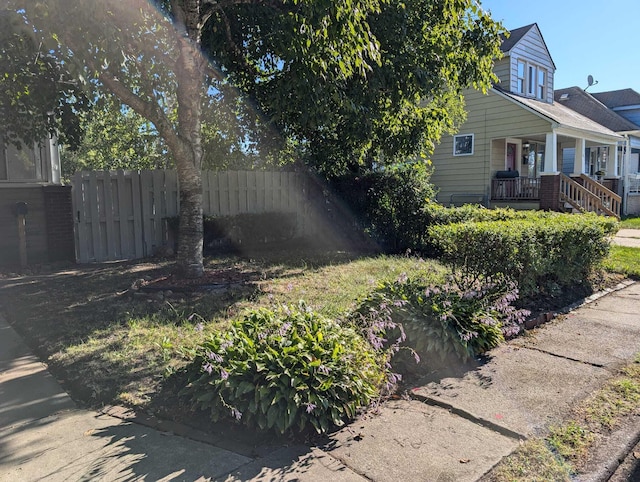 view of property exterior featuring covered porch and fence