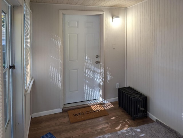 doorway to outside featuring radiator heating unit, wood finished floors, and baseboards