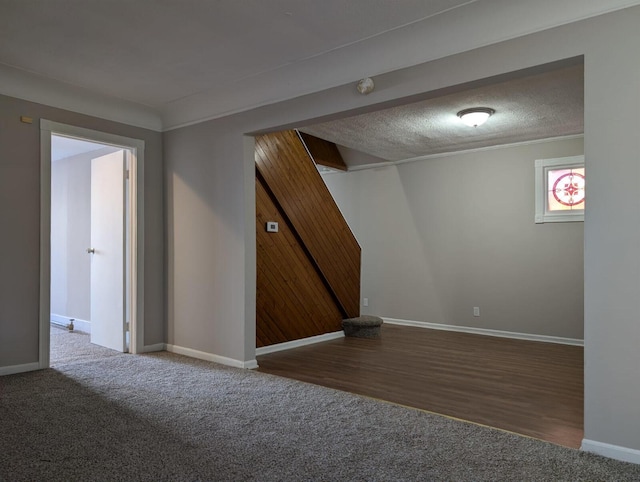 unfurnished room with a textured ceiling, baseboards, and carpet flooring