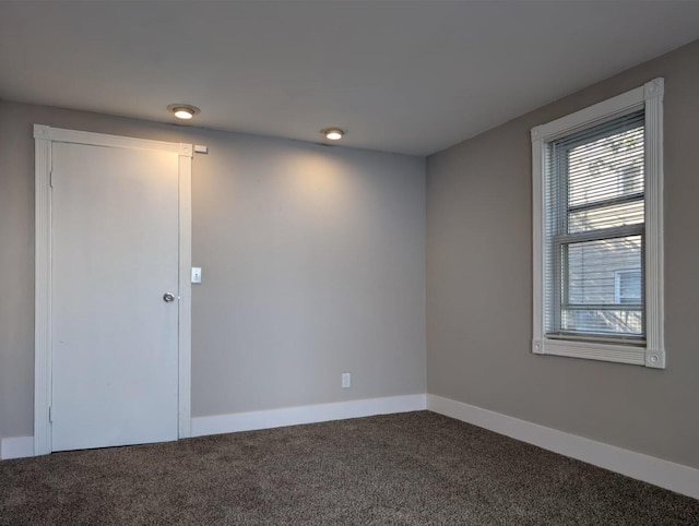 unfurnished room with carpet floors and baseboards