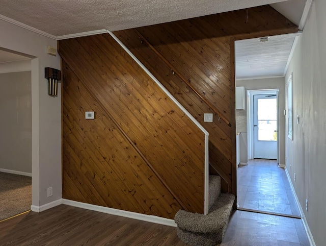 interior space featuring ornamental molding, stairway, a textured ceiling, and wood finished floors