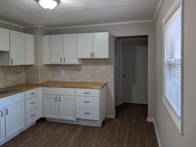 kitchen featuring dark wood-style flooring, white cabinets, crown molding, and backsplash