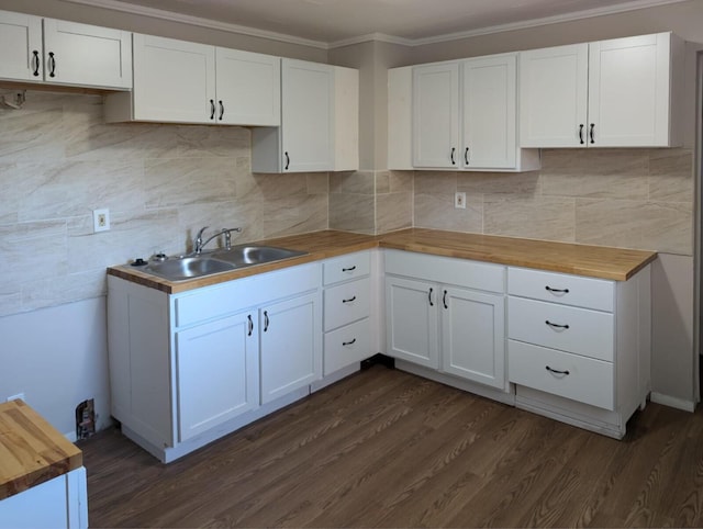 kitchen featuring butcher block countertops, dark wood-type flooring, a sink, and backsplash