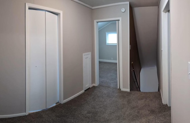 corridor featuring carpet floors, baseboards, and lofted ceiling