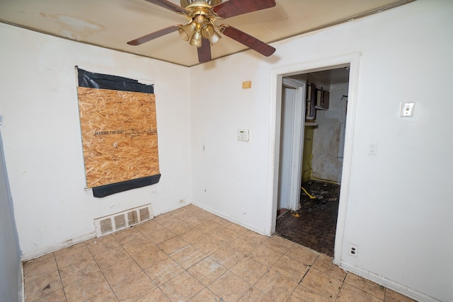 spare room featuring baseboards, visible vents, and a ceiling fan