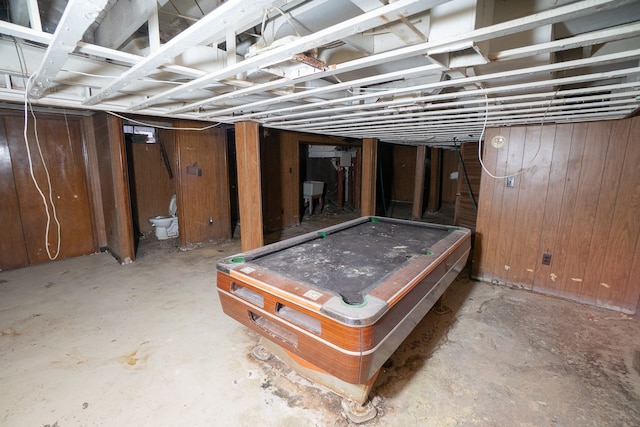 unfinished basement featuring wood walls, a sink, and pool table