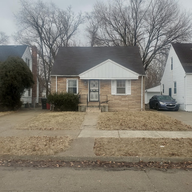 view of front of house with stone siding, board and batten siding, and concrete driveway