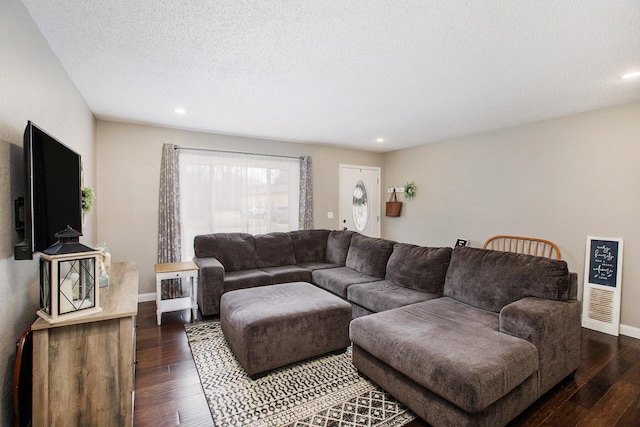 living room with a textured ceiling, baseboards, dark wood-type flooring, and recessed lighting