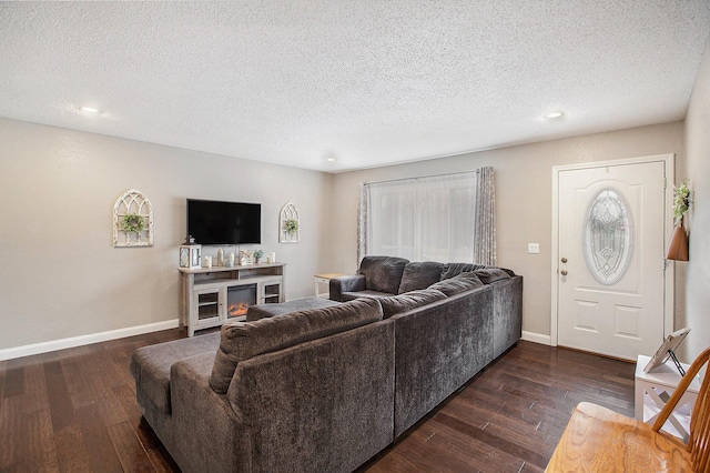 living area featuring dark wood-style floors, baseboards, and a textured ceiling