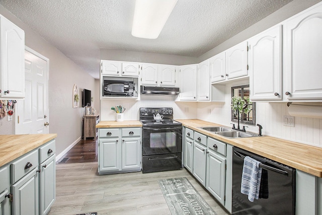 kitchen featuring gray cabinets, a sink, wooden counters, and black appliances