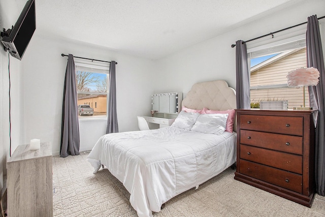 bedroom featuring light colored carpet and a textured ceiling