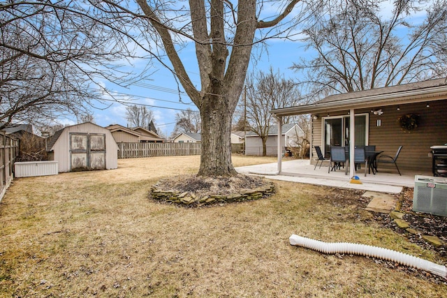 view of yard featuring a patio, a fenced backyard, central air condition unit, an outdoor structure, and a storage unit