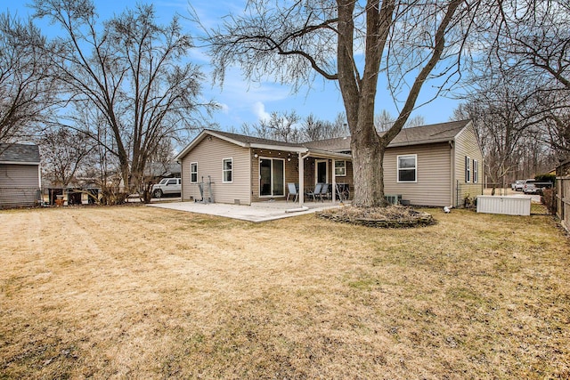 rear view of property featuring driveway, a patio, fence, a yard, and brick siding