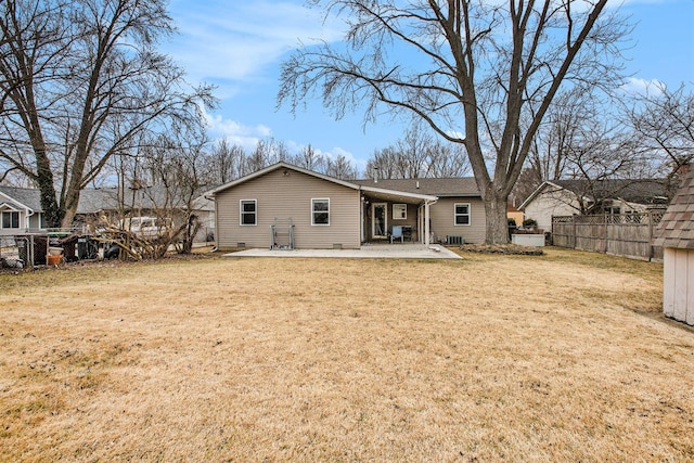 rear view of house with a patio, a lawn, and fence