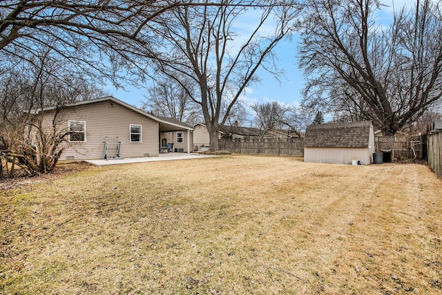 view of yard with an outbuilding, a patio area, a fenced backyard, and a storage unit