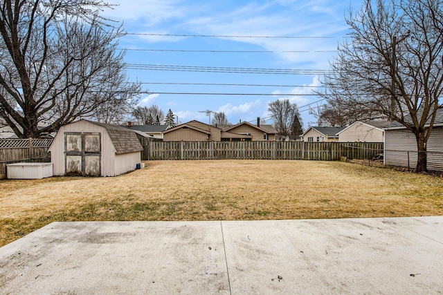 view of yard featuring a fenced backyard, an outdoor structure, and a storage shed