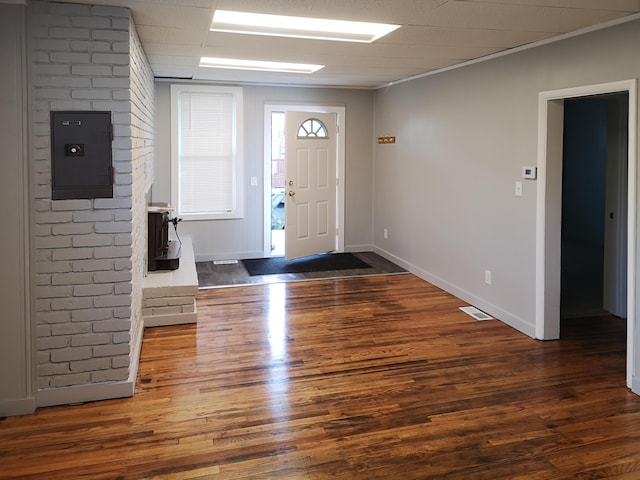 foyer featuring baseboards, electric panel, visible vents, and wood finished floors