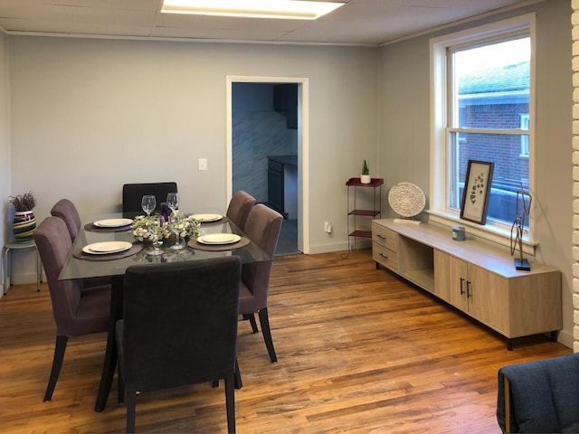 dining space featuring light wood-style flooring and baseboards