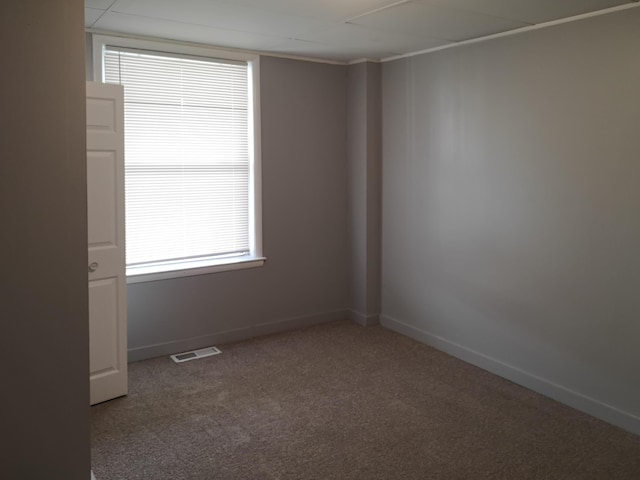 carpeted spare room featuring visible vents and baseboards